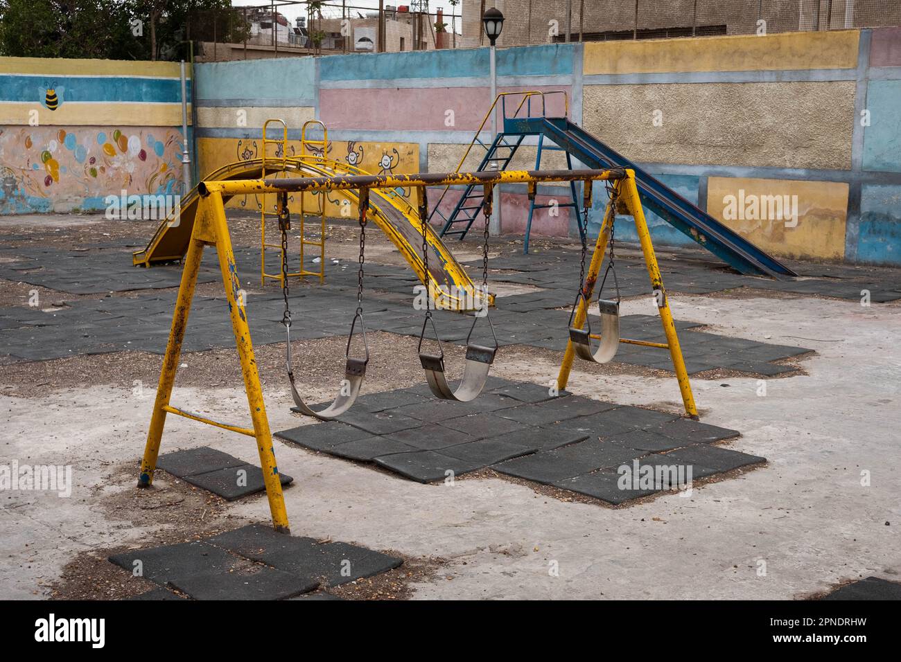 run down swing on old children`s  playground Stock Photo